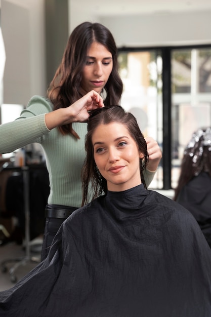 Woman getting treatment at hairdresser shop