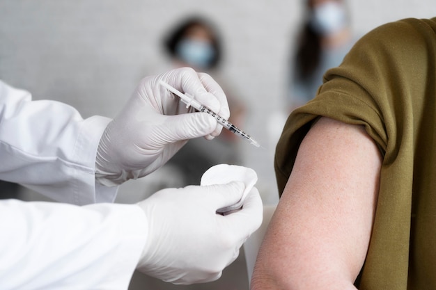 Free Photo woman getting vaccine shot by doctor