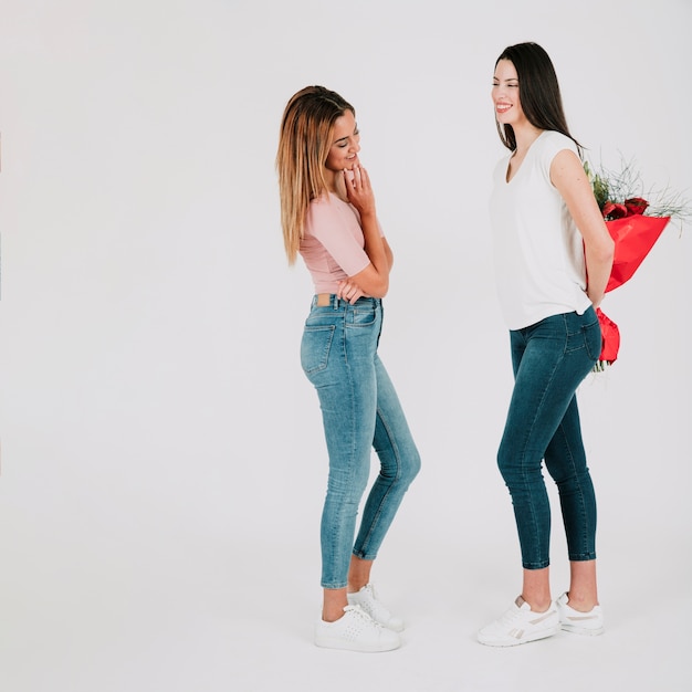 Woman gifting bouquet to girlfriend