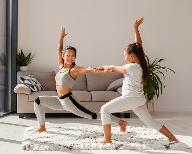 Woman and girl doing sport indoors together