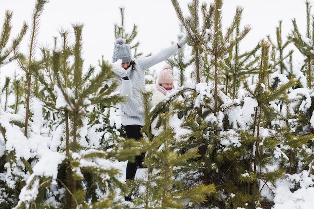 Free Photo woman and girl playing near spruces