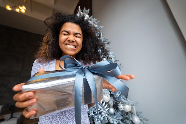 Woman gives a gift to his friend in the camera Portrait of a young woman of Afro appearance ethnic black curly hair brunette