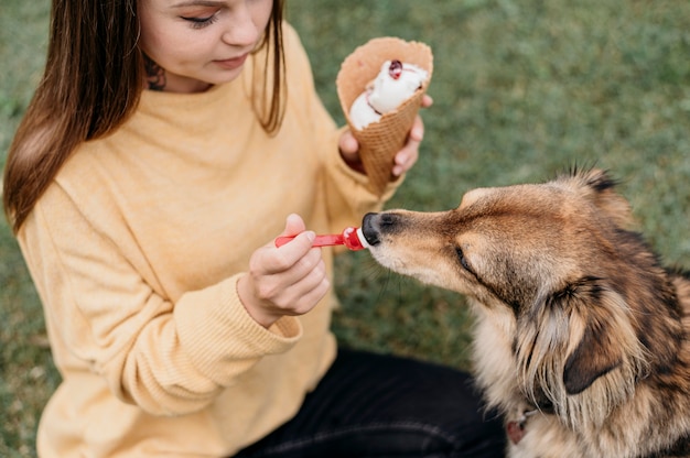 Woman giving ice cream to her dog