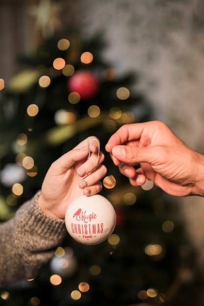 Woman giving to man ornament Christmas ball 