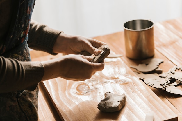 Free Photo woman giving shape to piece of clay