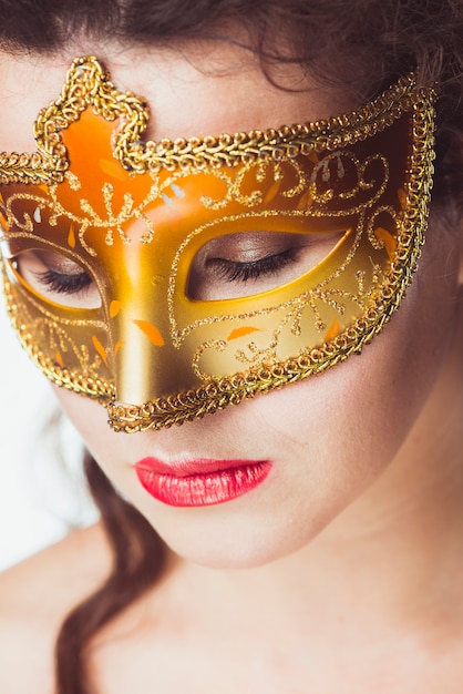 Free Photo woman in golden mask with eyes closed