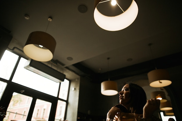 Woman in golden suit sits in the cafe 