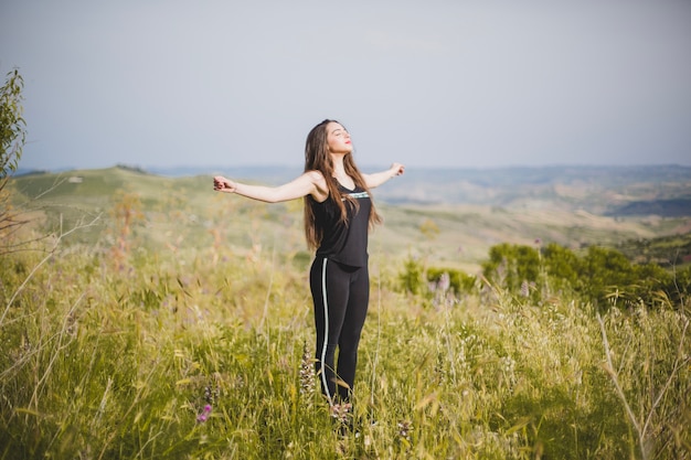 Free photo woman in grass with hands apart