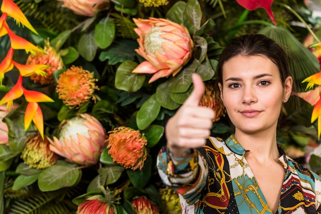 Free photo woman in green house showing thumb up