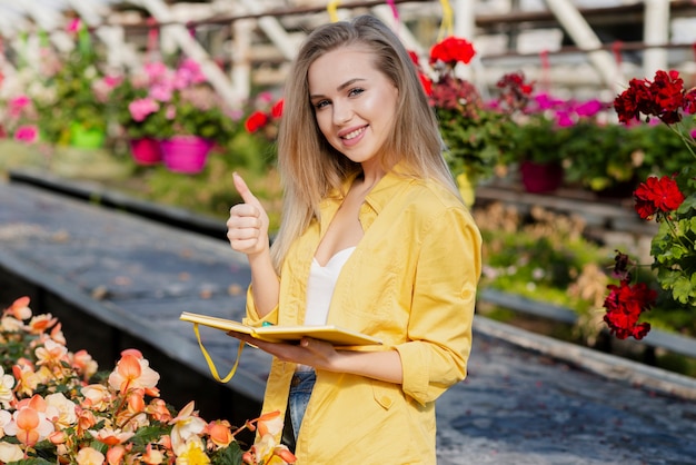 Woman in greenhouse show ok sign