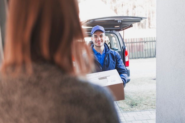 Free Photo woman greeting deliveryman on porch