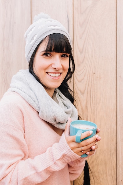 Free Photo woman in grey cap with coffee cup