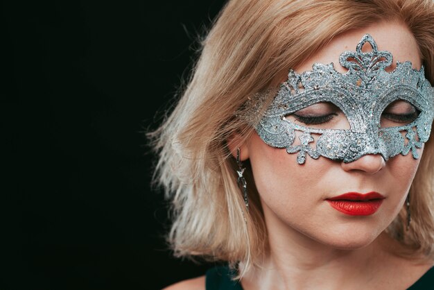 Free Photo woman in grey carnival mask closing eyes 