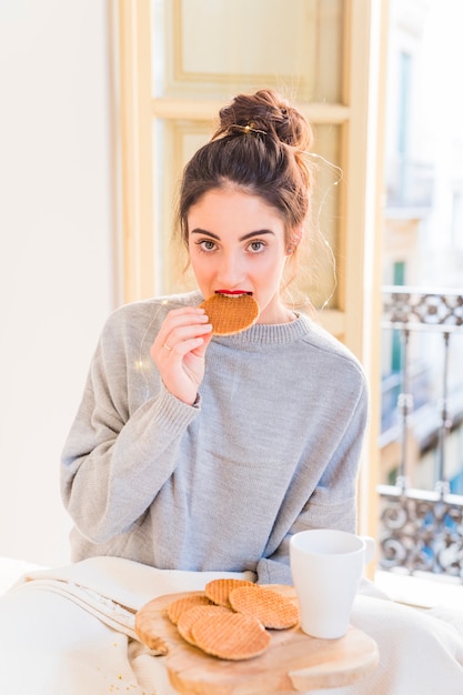 Woman in grey eating cookies 