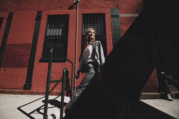 Woman in grey suit enjoys wind on the street of New York city