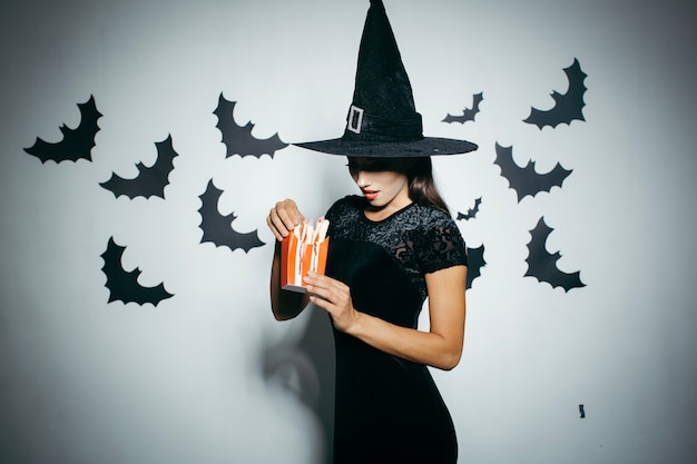 Woman in Halloween hat with food box