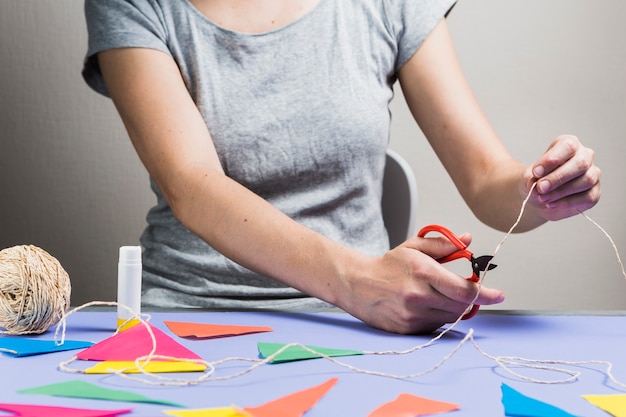 Free photo woman hand cutting string with scissor during making bunting