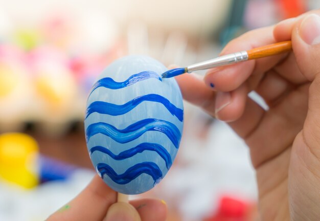 Woman hand  decorating Easter eggs