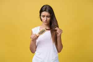 Free photo woman hand holding her long hair with looking at damaged splitting ends of hair care problems