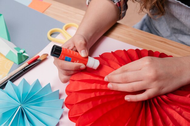 Woman hand sticking origami paper while making origami flower