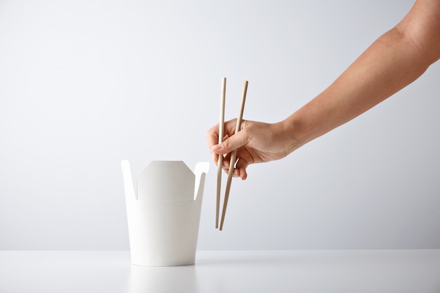 Free photo woman hand with chopsticks near blank takeway box with tasty noodles isolated on white retail set presentation