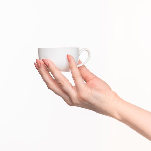 Woman hand with perfect white cup on white background