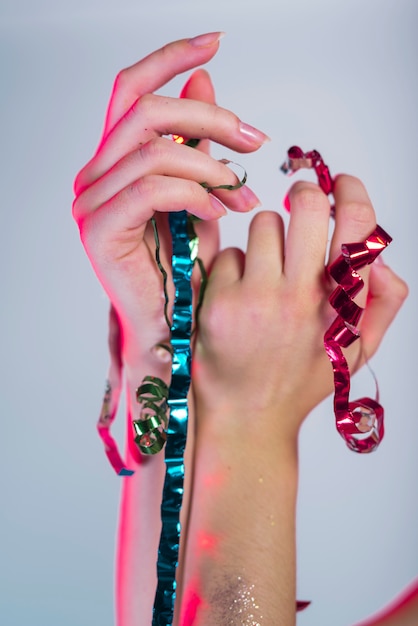 Free Photo woman hands holding multicolored ribbons