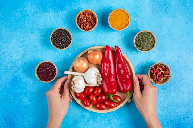 Woman hands holding plate of vegetables.