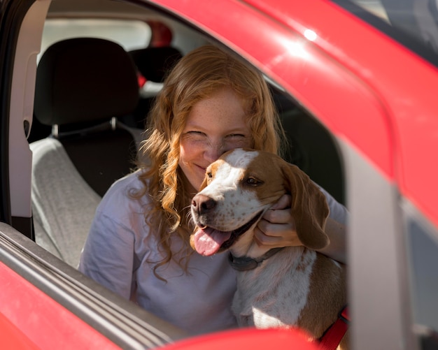 Free Photo woman and happy dog going on a ride with the car