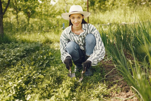 Woman in a hat working in a garden