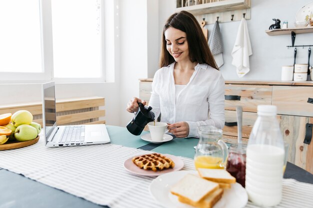 Woman having breakfast at the kitchen