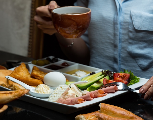 Woman having a cup of tea an breakfast foods