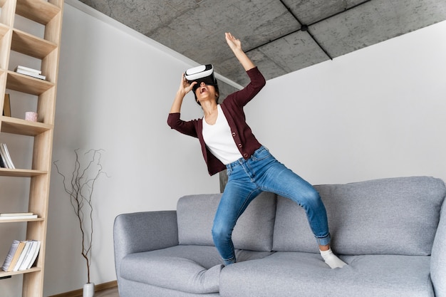 Free photo woman having fun at home with virtual reality headset