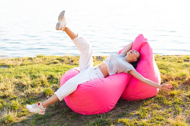 Woman having a fun time on pink beanbags 