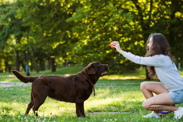 Woman having fun with her dog in garden