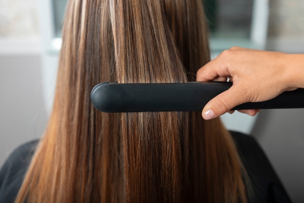 Woman having hair treatment of latino hair salon