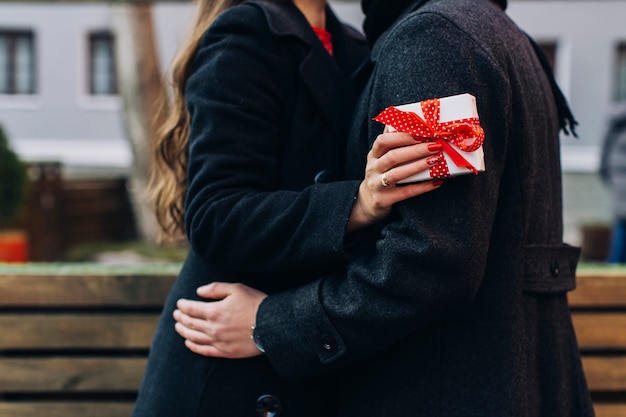 Woman having present and embracing with man