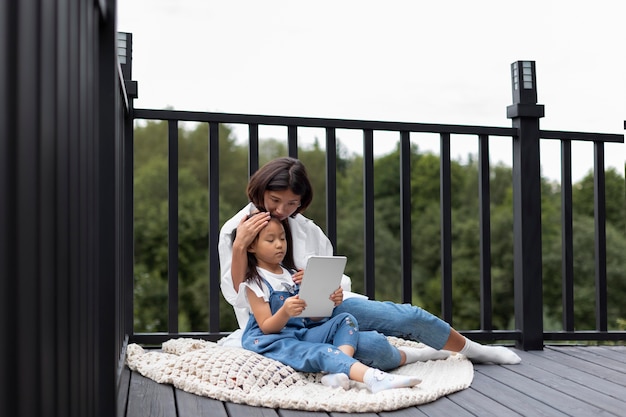 Free Photo woman having a video call with her husband next to their daughter outdoors