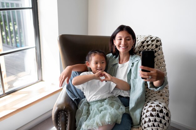 Woman having a video call with her husband next to their daughter