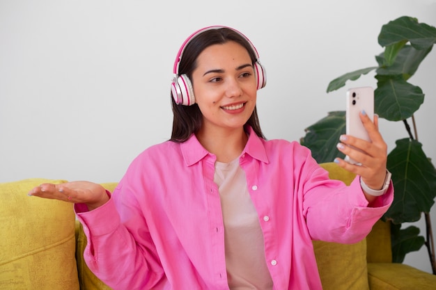 Free photo woman having a videocall on smartphone while sitting on the sofa at home