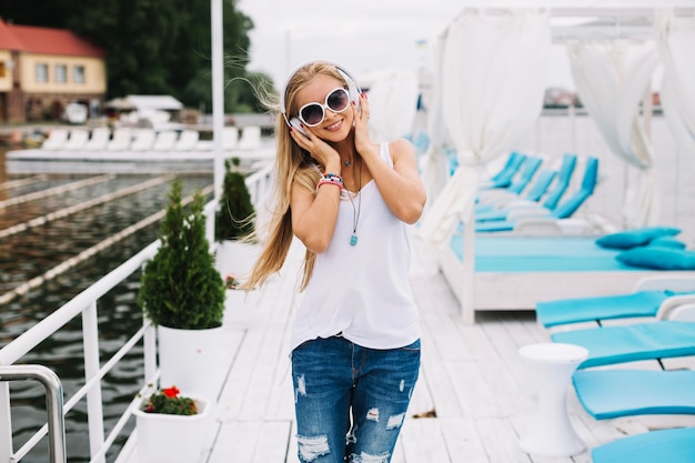 Free Photo woman in headphones walking on pier