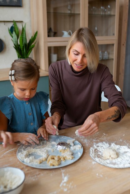 Woman helping kids cook front view