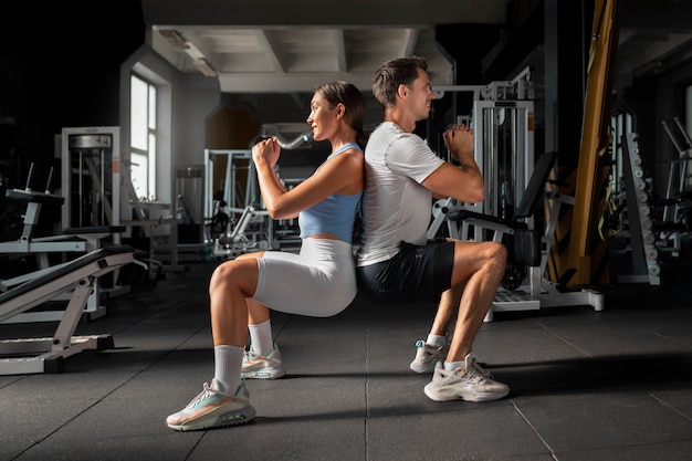 Woman helping man at gym