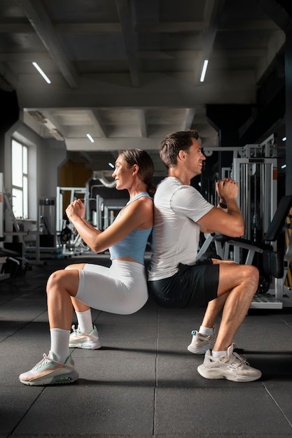 Woman helping man at gym