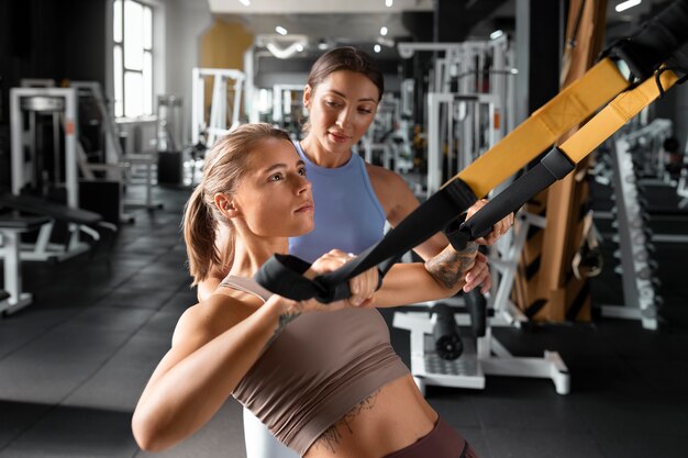 Woman helping man at gym