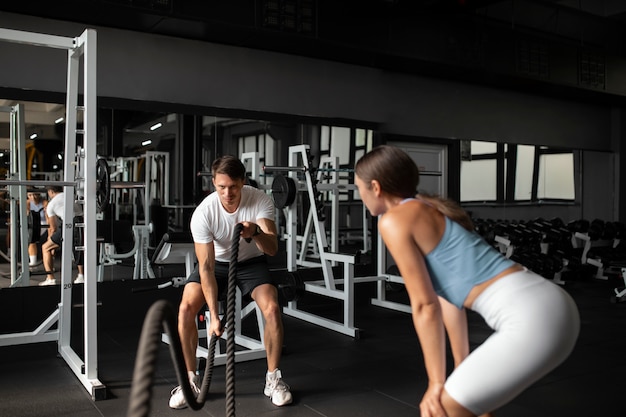 Woman helping man at gym