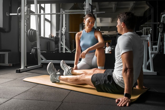 Free Photo woman helping man at gym