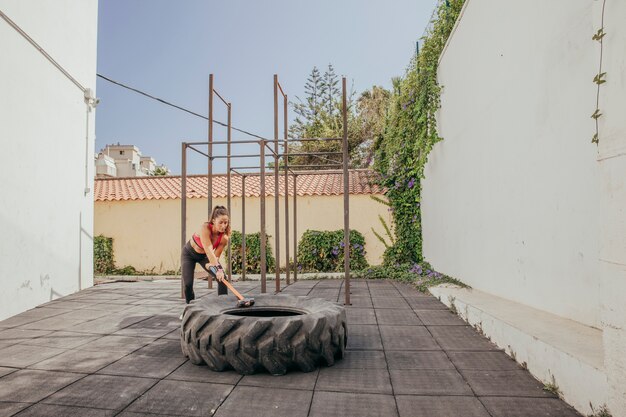 Woman hitting wheel with hammer