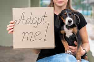 Free photo woman holding adopt me sign and rescue dog