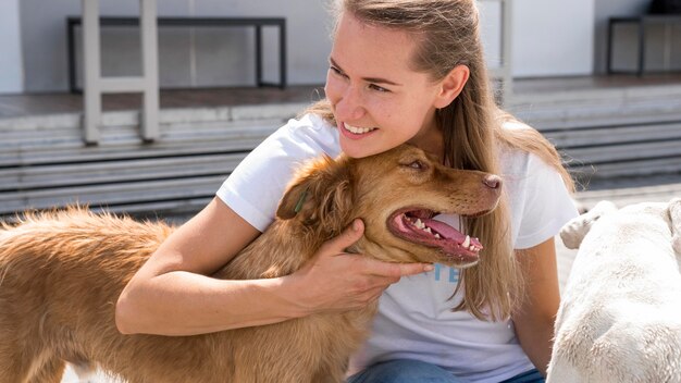 Woman holding adorable dog in shelter